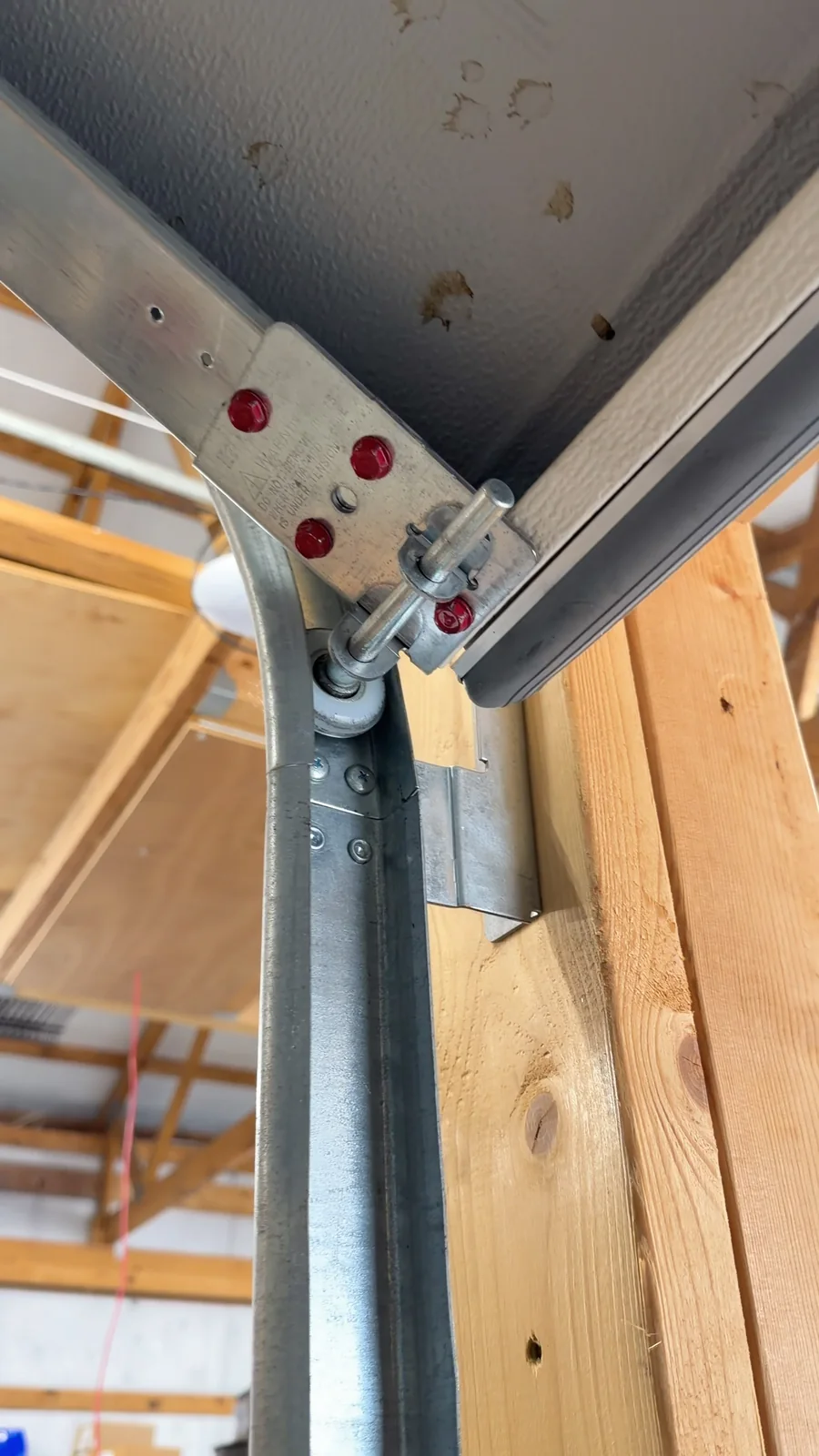 Close-up of a garage door roller and hinge inside the track