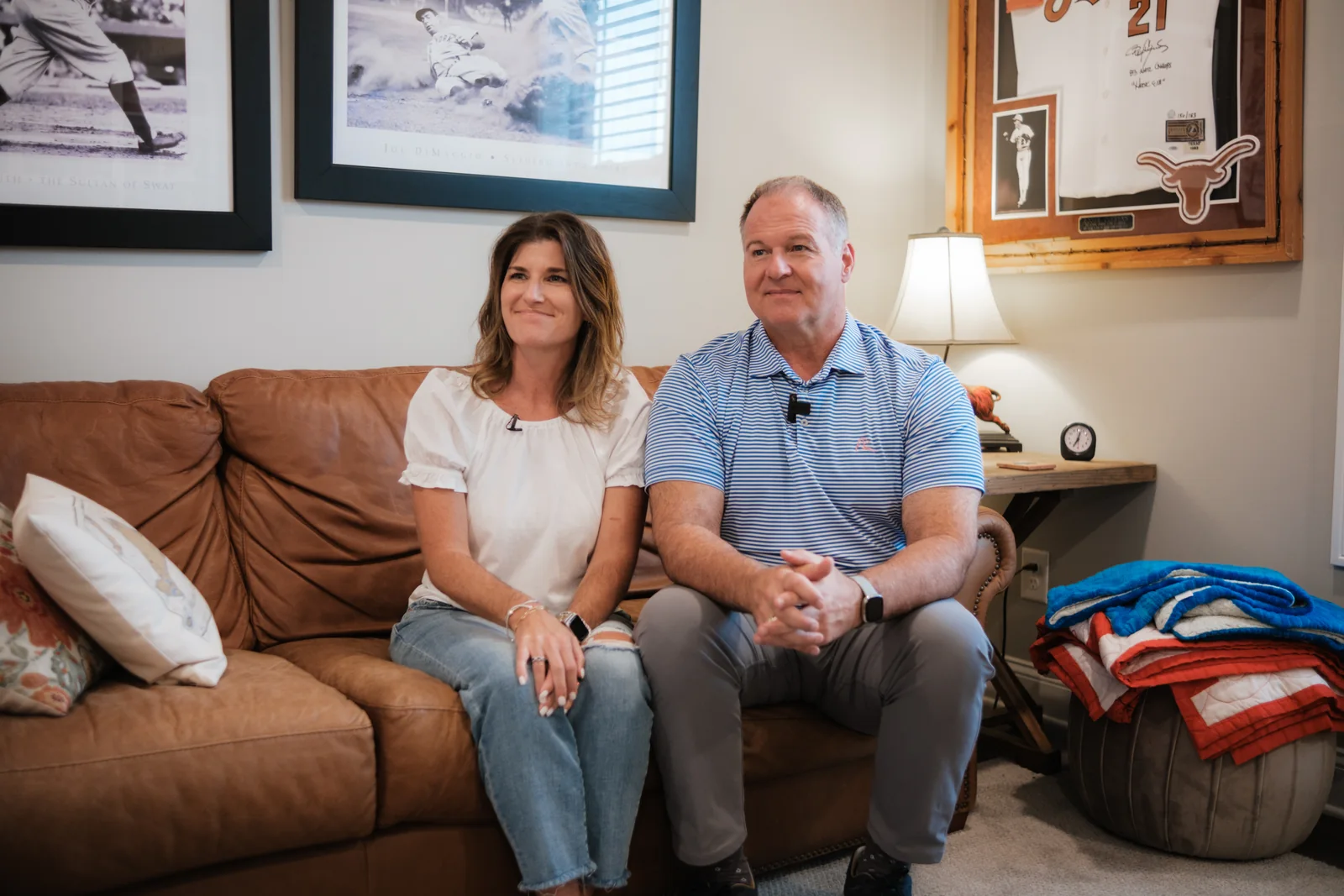 Two homeowners sitting together on a leather sofa in their living room