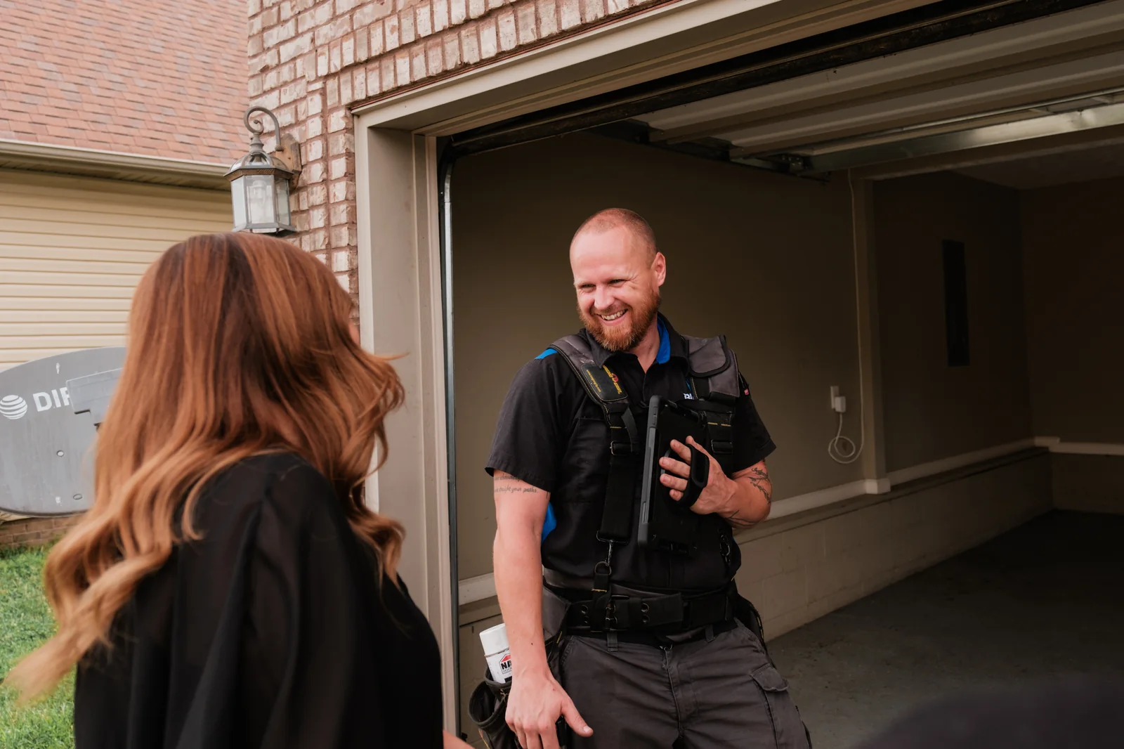 Blue Jay technician talking with a homeowner at an open garage