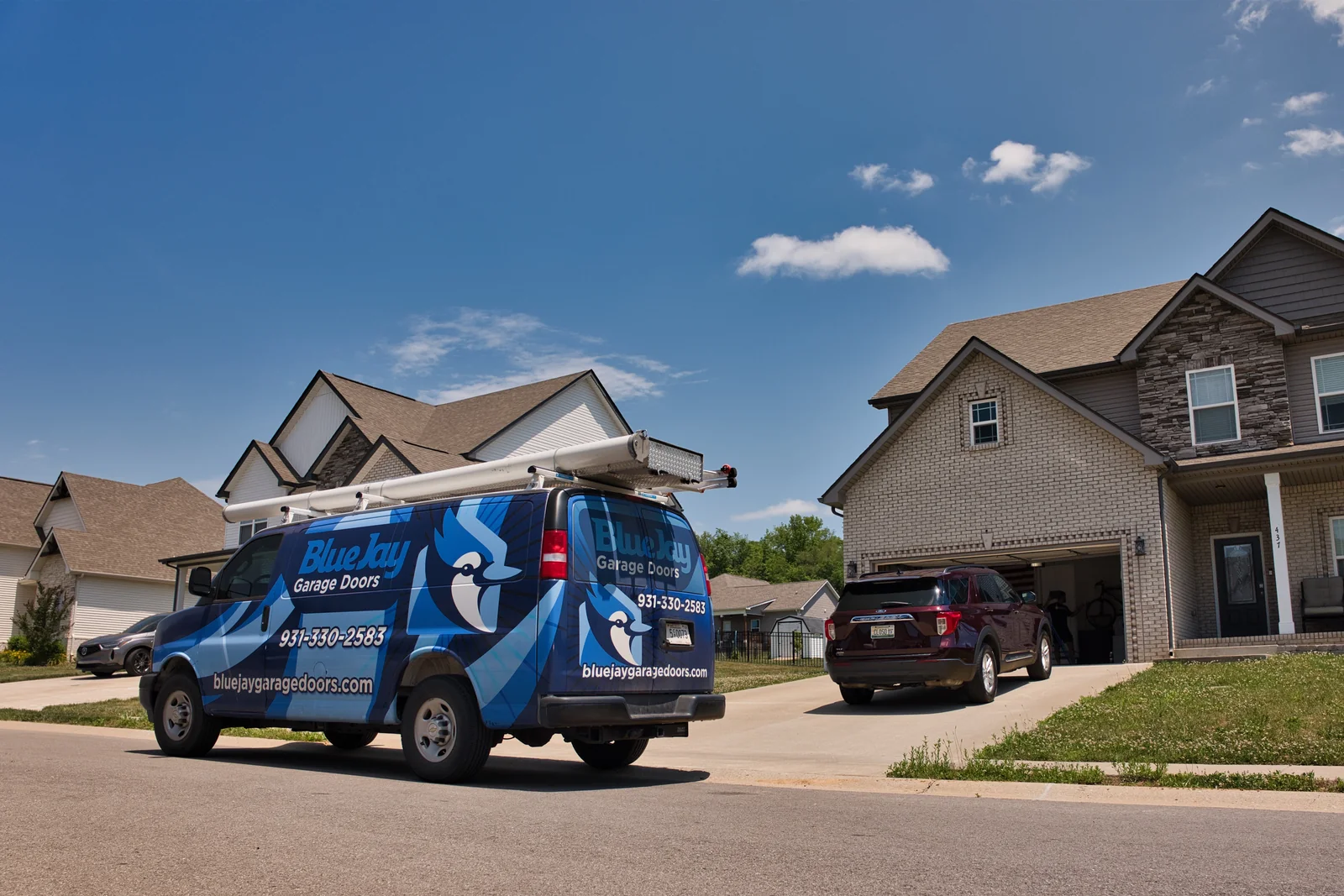 Rear view of a Blue Jay service van parked on a residential street