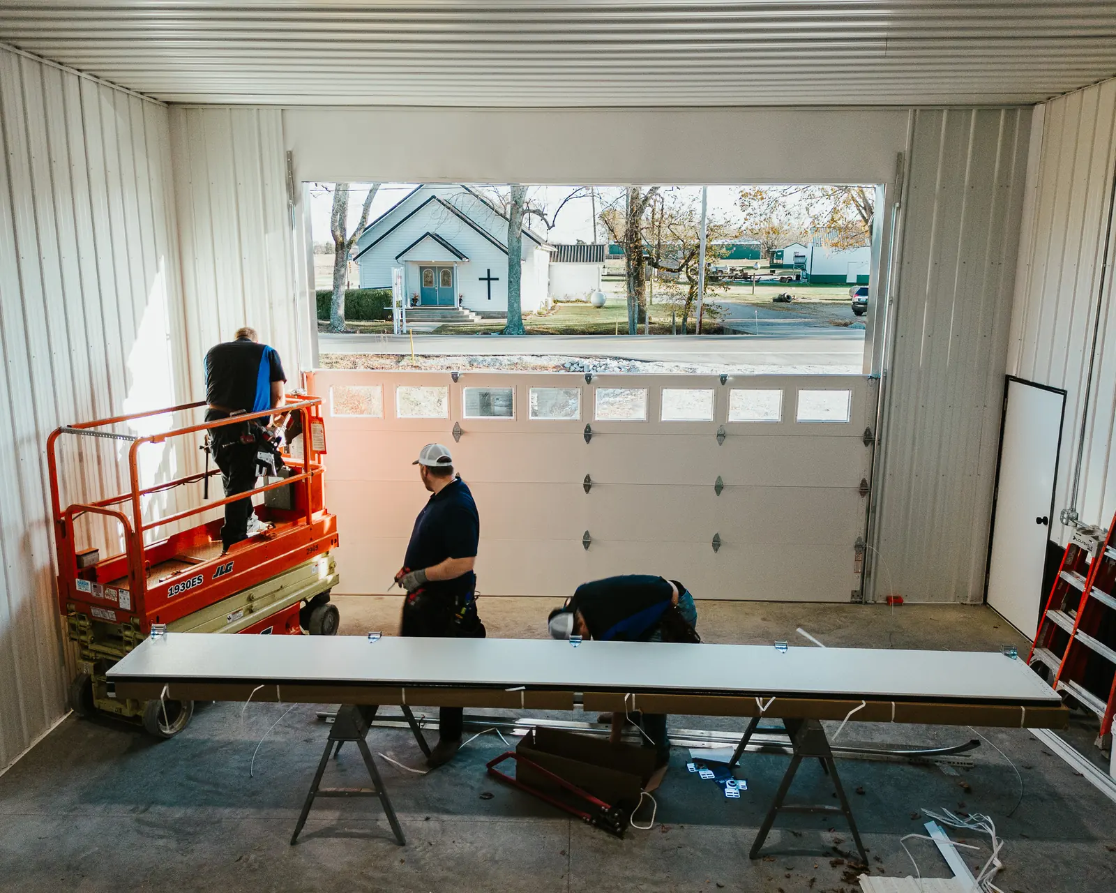 Blue Jay installers working on a large white garage door