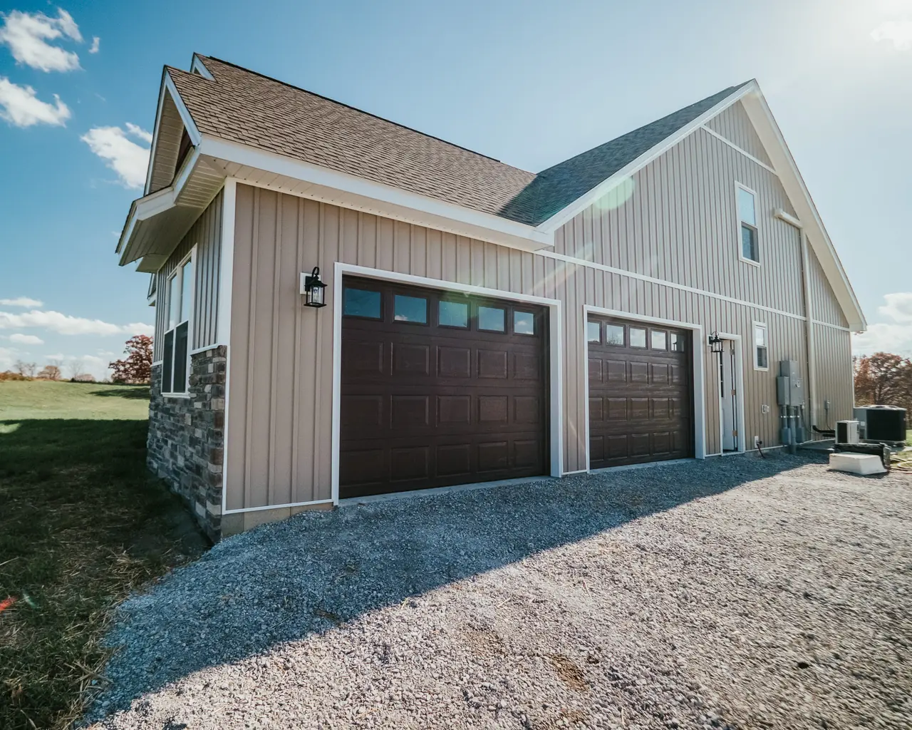 Two brown carriage-style garage doors on a light-colored garage