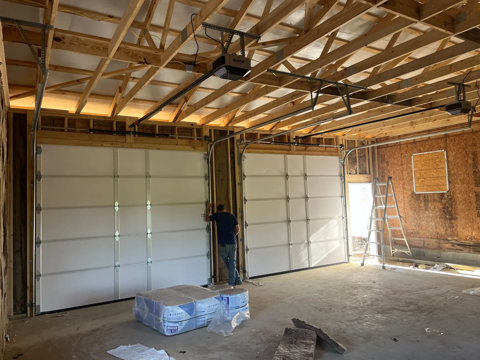 White sectional garage door and overhead hardware viewed from inside