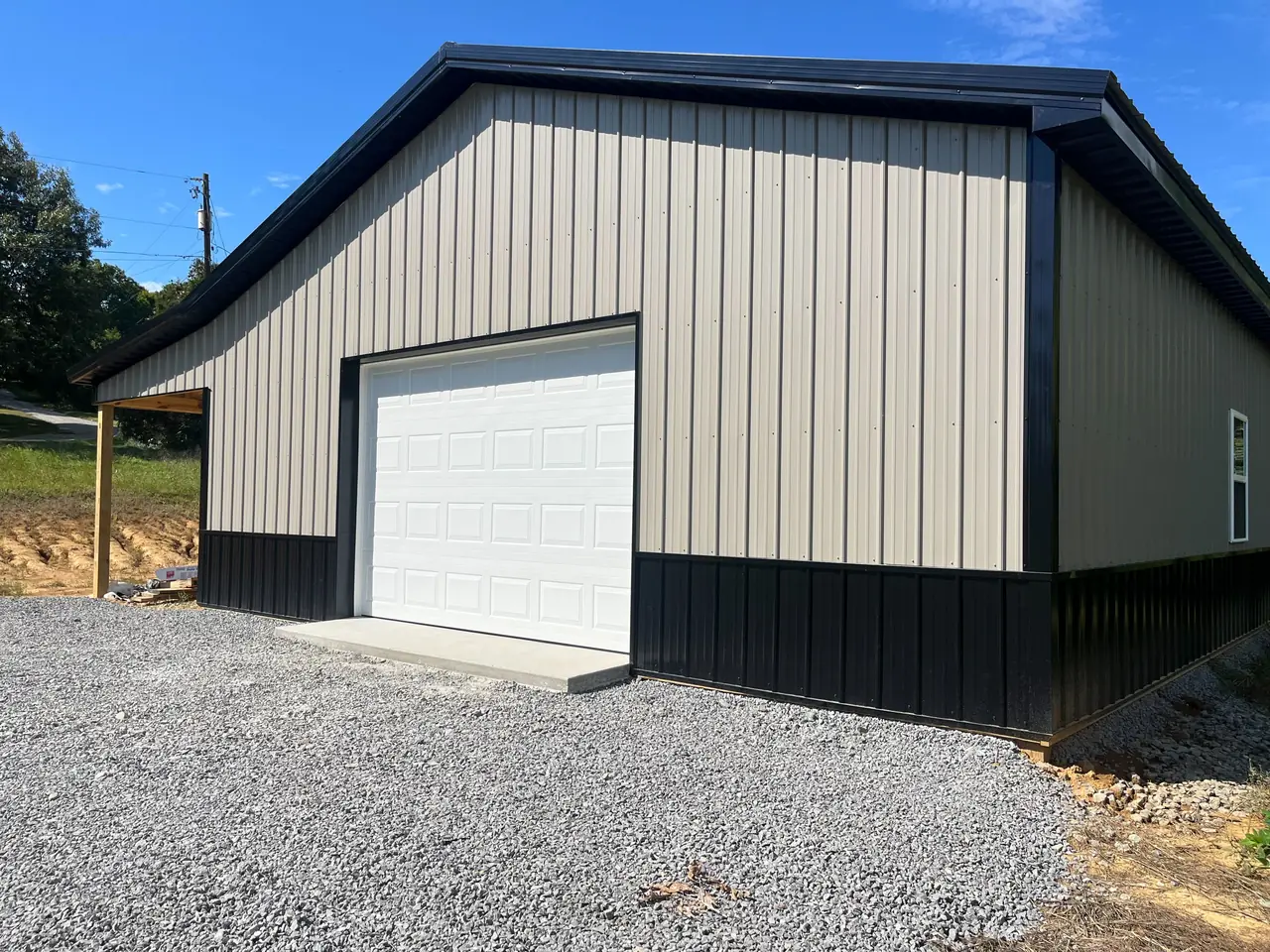 White garage door on a detached garage with a covered side area