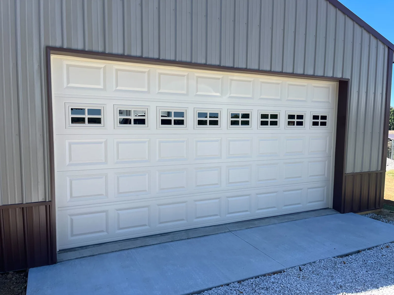 Wide white garage door with a row of top windows