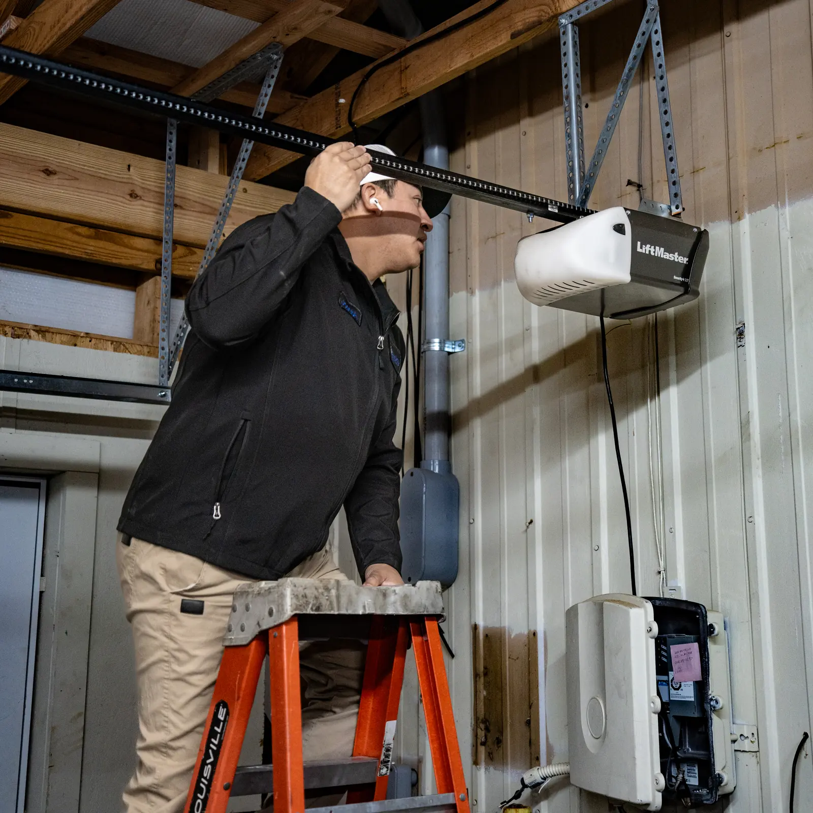 Blue Jay technician working on a ceiling-mounted garage door opener