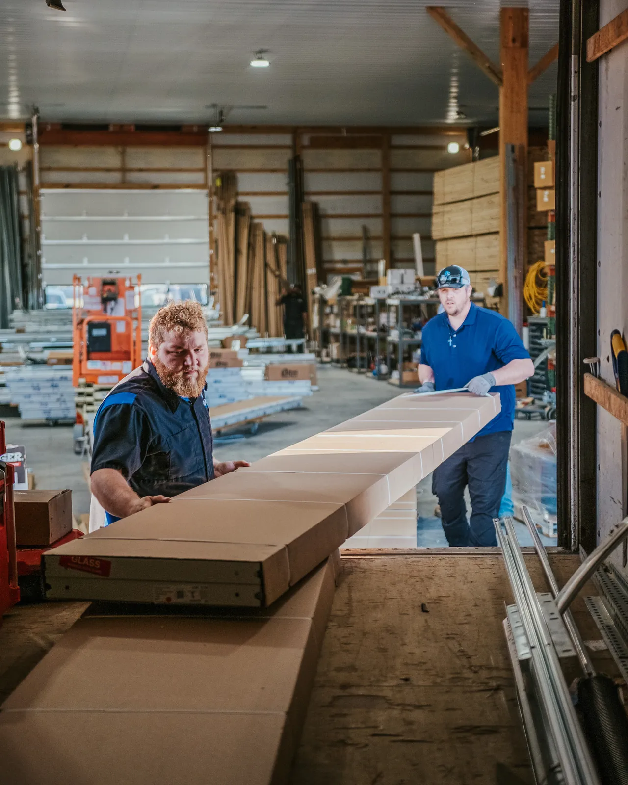 Blue Jay team members handling boxed garage door sections in the warehouse