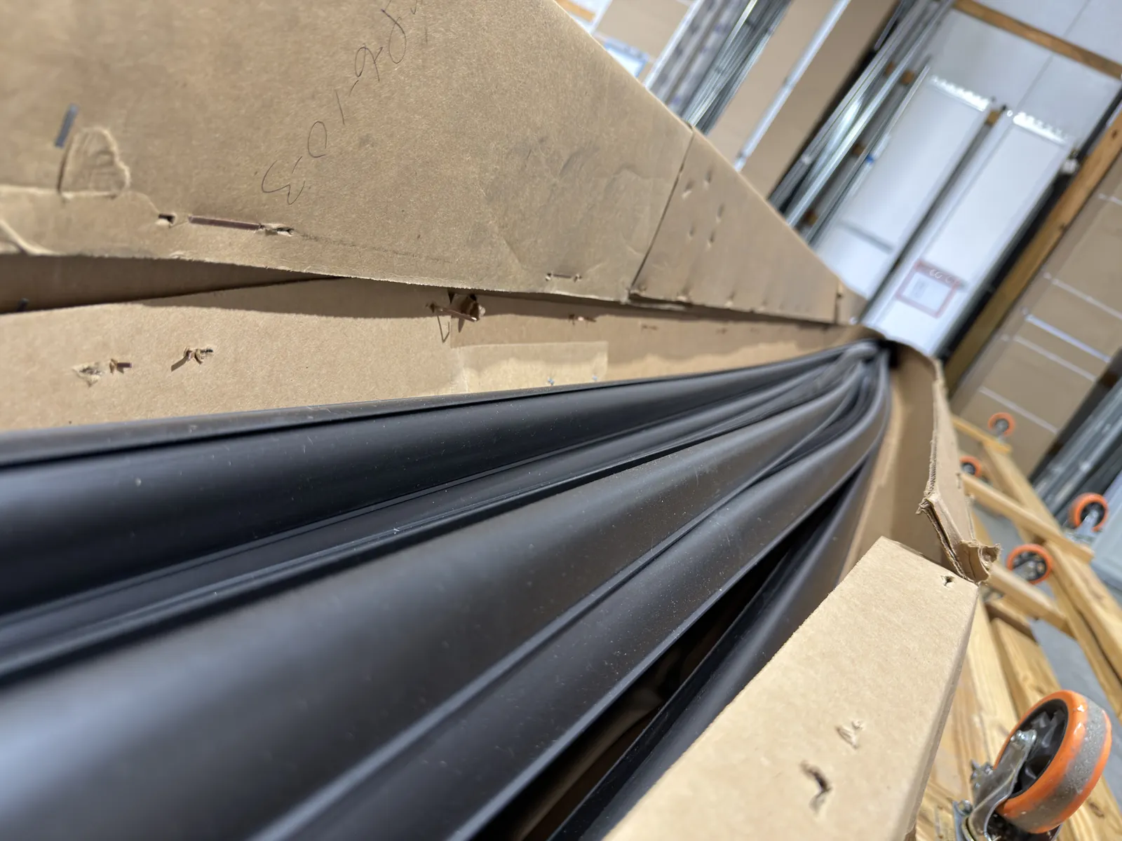 Lengths of flexible black garage door seal laid out on a workbench