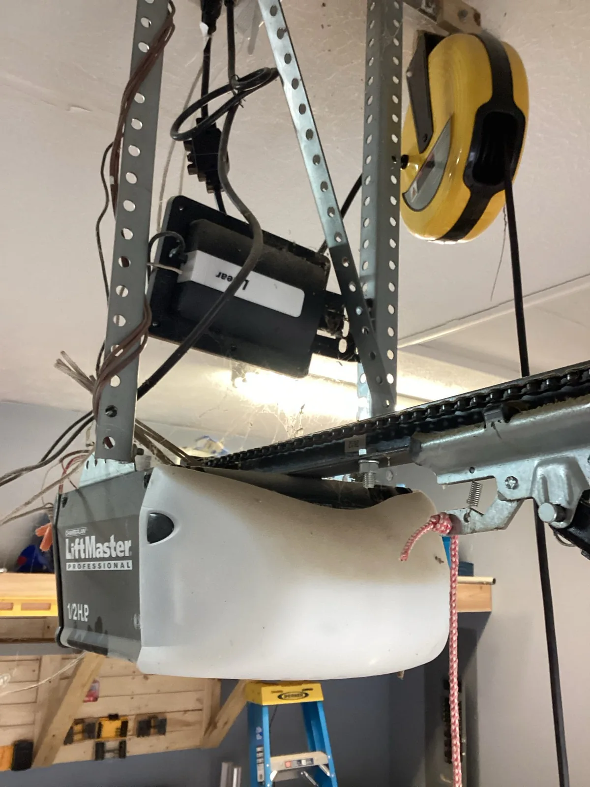 Ceiling-mounted LiftMaster garage door opener and chain rail inside a garage