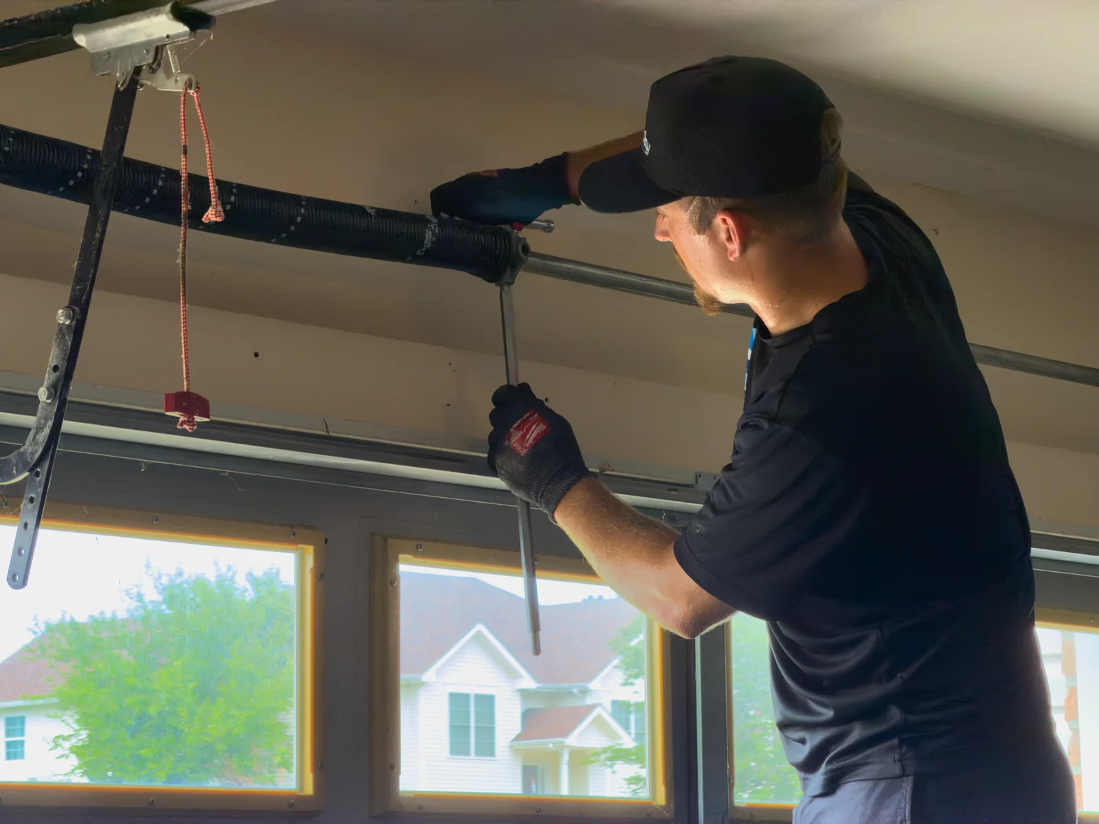 Blue Jay technician working on the torsion spring above a garage door