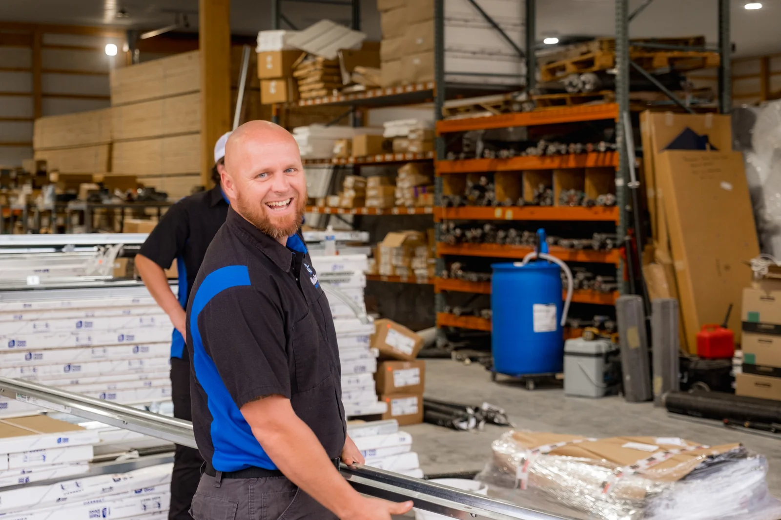 Smiling Blue Jay team member in the warehouse among door parts and shelving