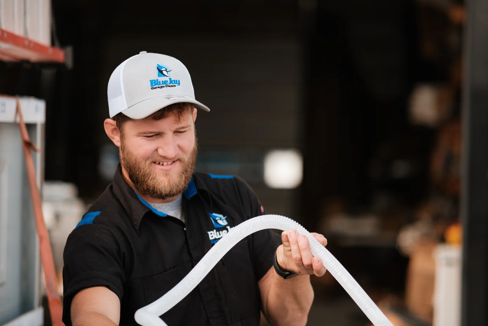 Blue Jay team member holding a length of flexible seal material in the shop