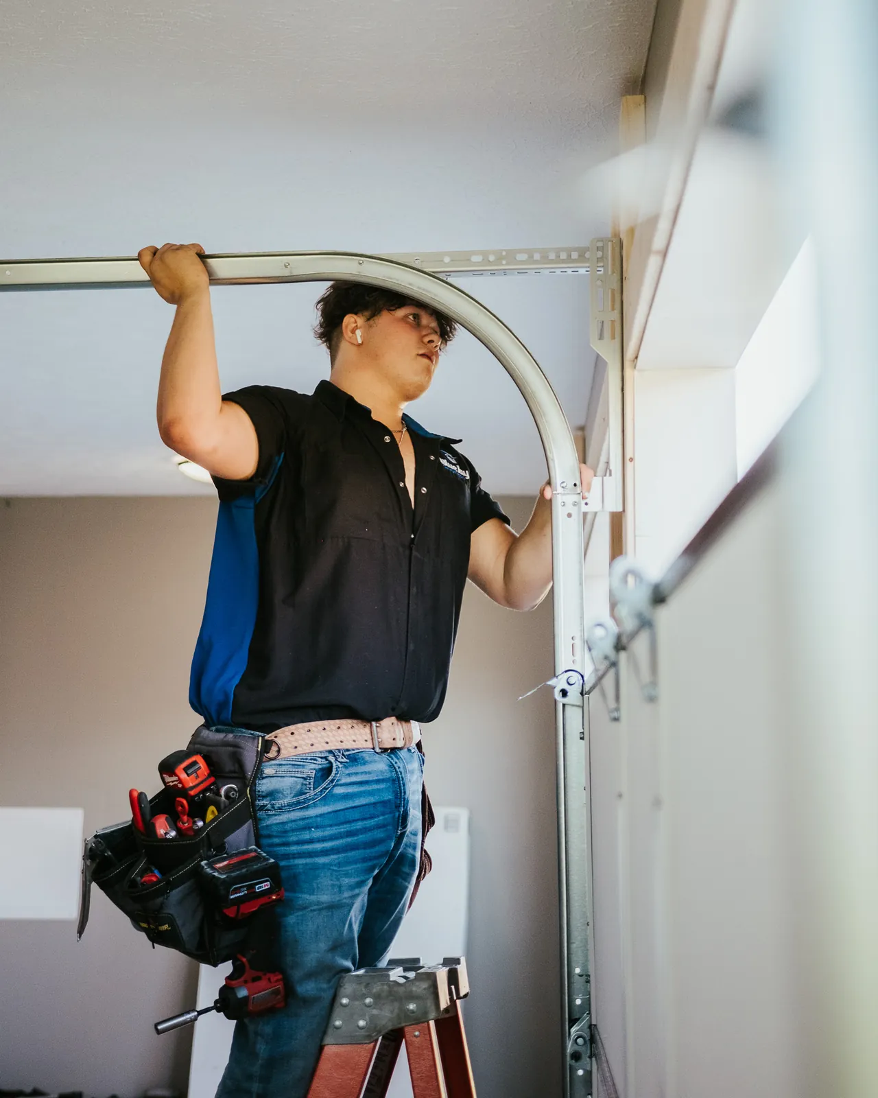 Blue Jay installer checking a curved garage door track
