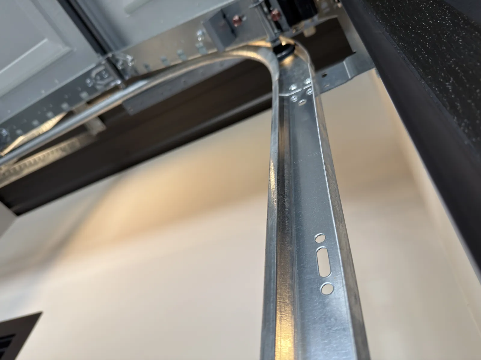 Close view of a garage door roller in the curved part of its track