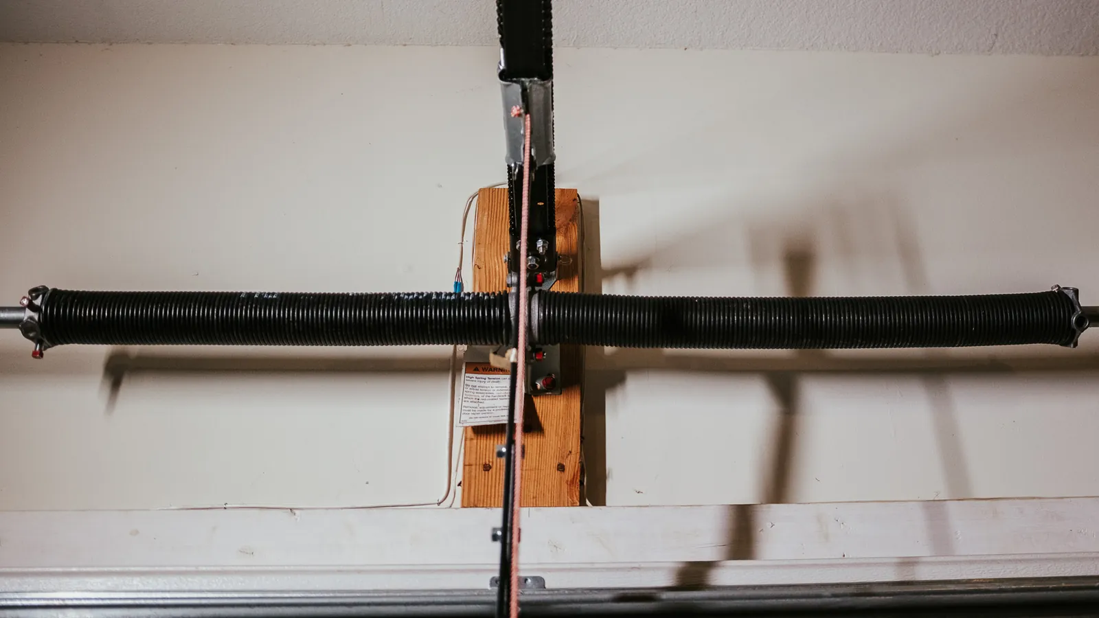 Torsion spring assembly and center support above a closed garage door