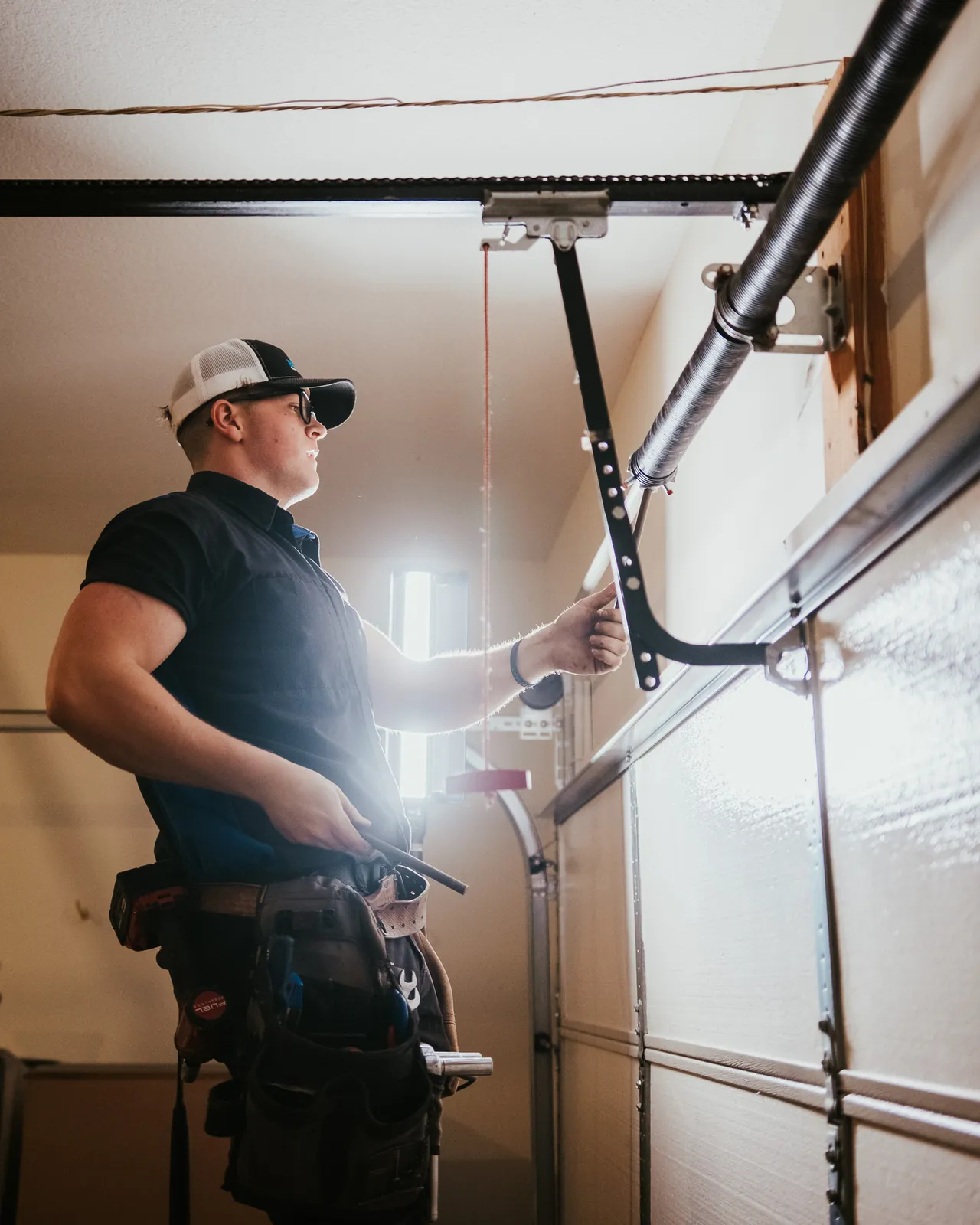 Blue Jay technician working on overhead spring and lifting hardware