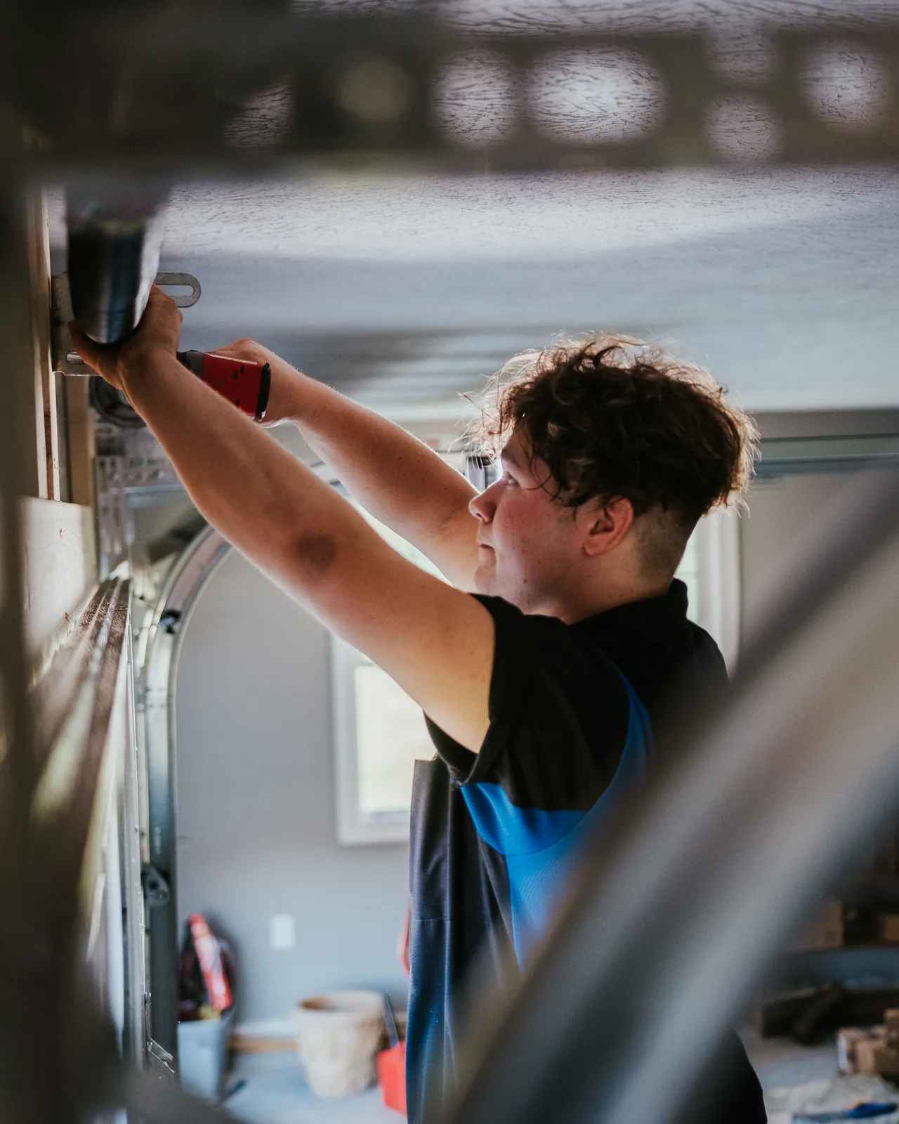 Blue Jay technician adjusting overhead garage door hardware