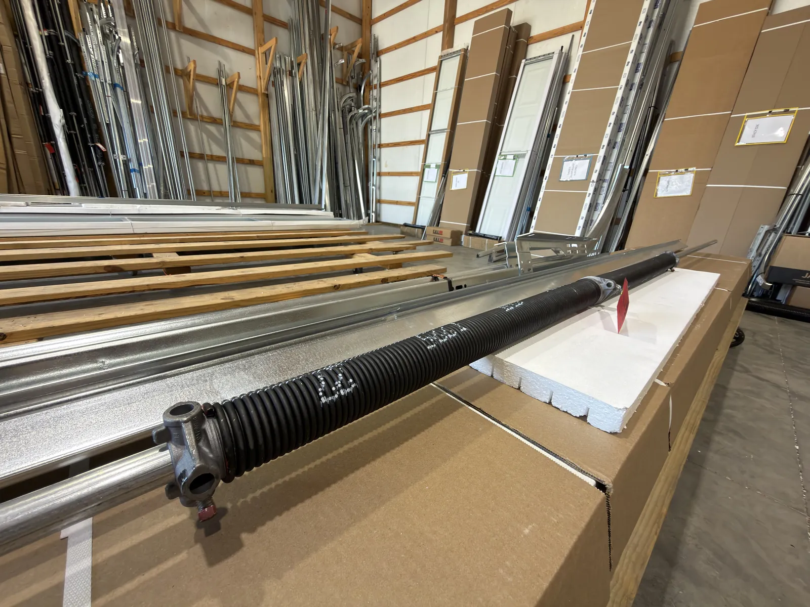 Garage door torsion spring laid on a warehouse workbench