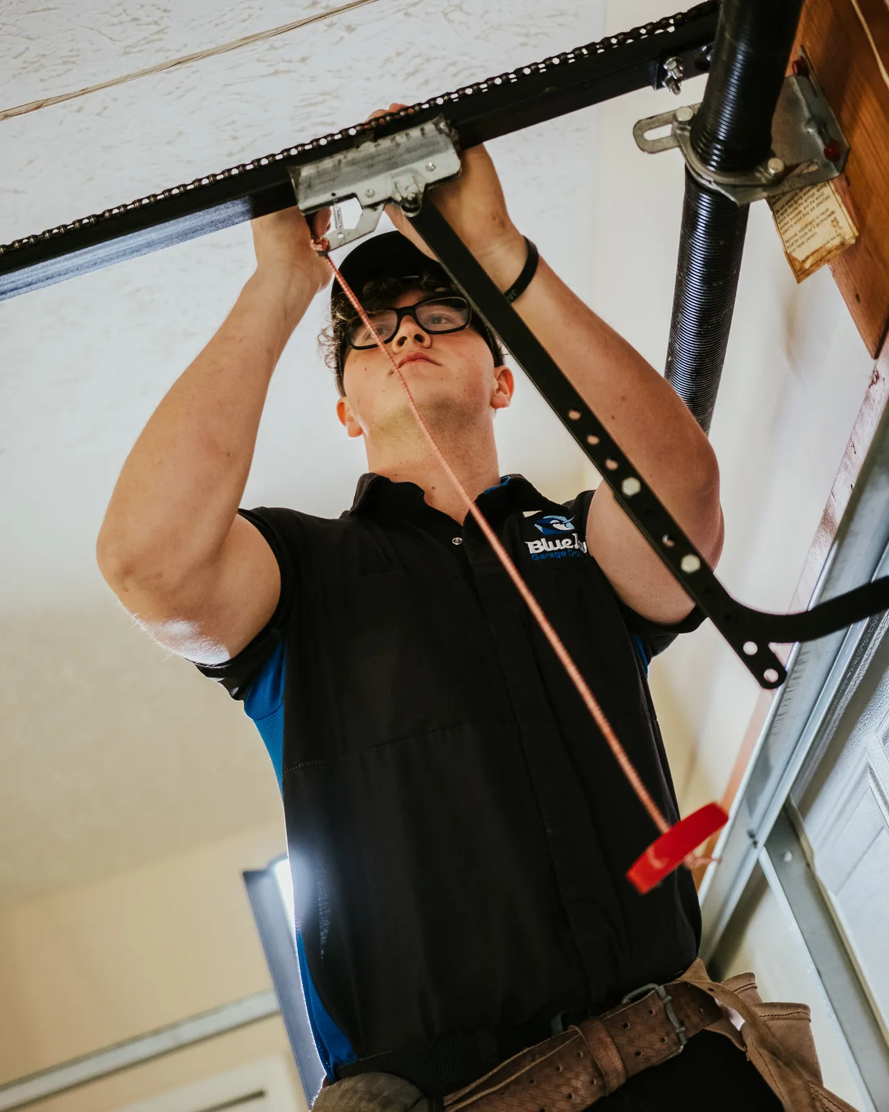 Blue Jay technician fitting a garage door opener rail