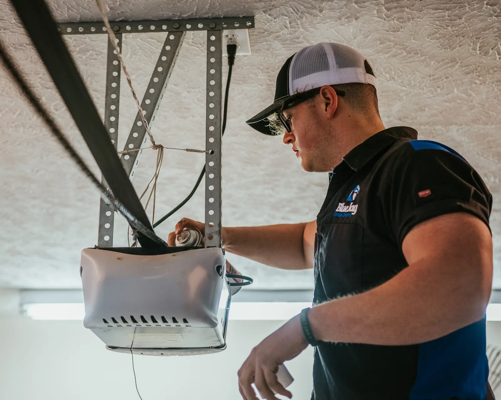 Blue Jay technician checking a ceiling-mounted garage door opener