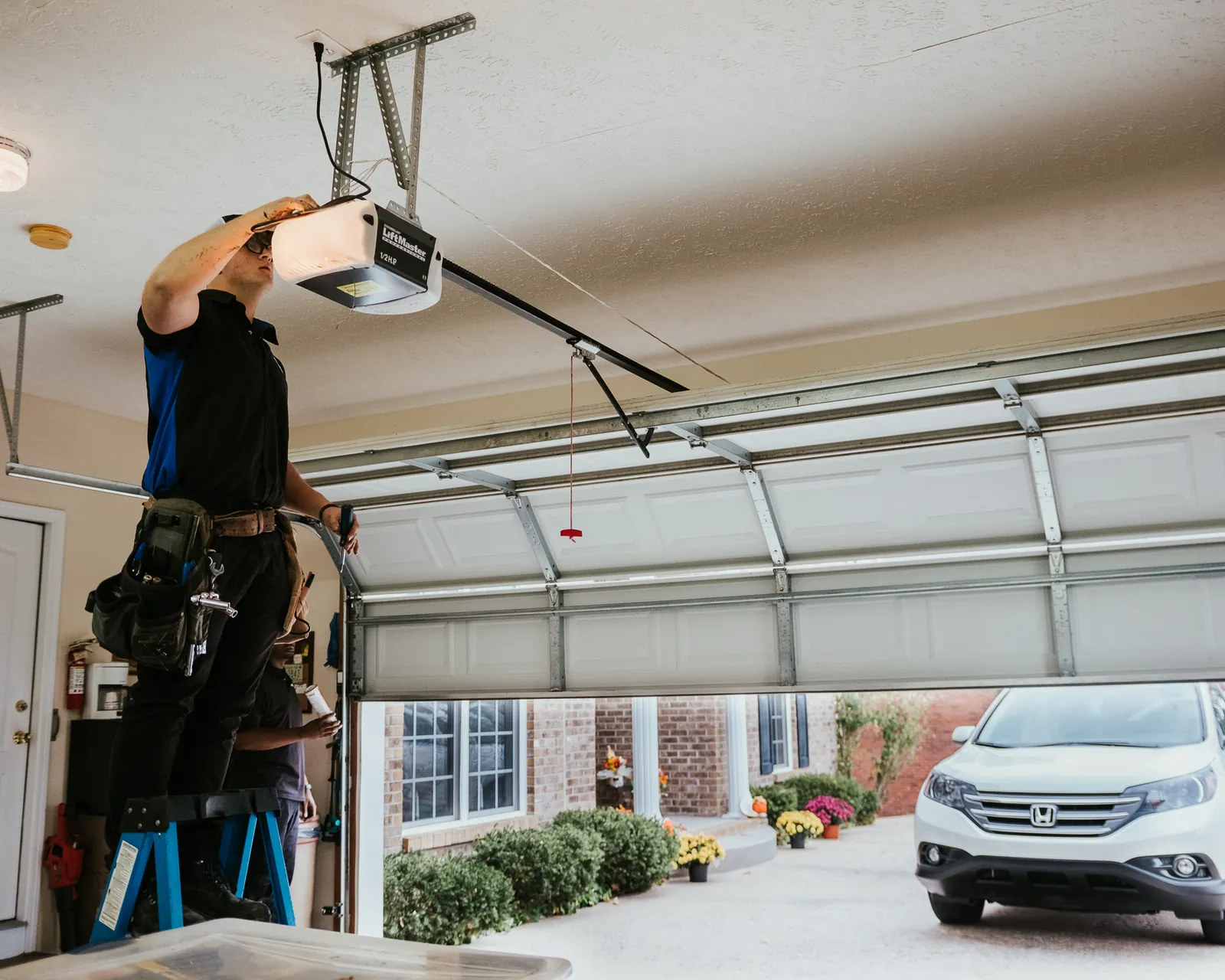 Blue Jay technician working on an opener inside an open residential garage