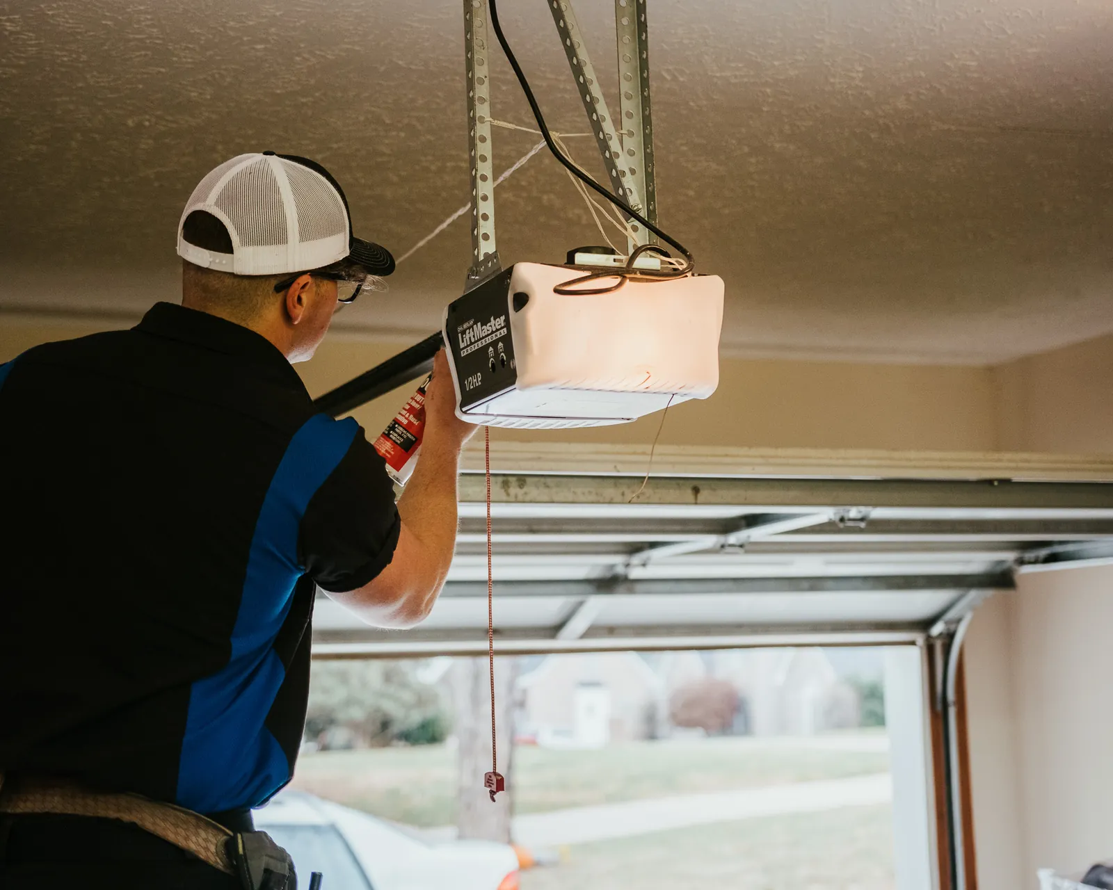 Blue Jay technician securing the ceiling supports for a garage door opener