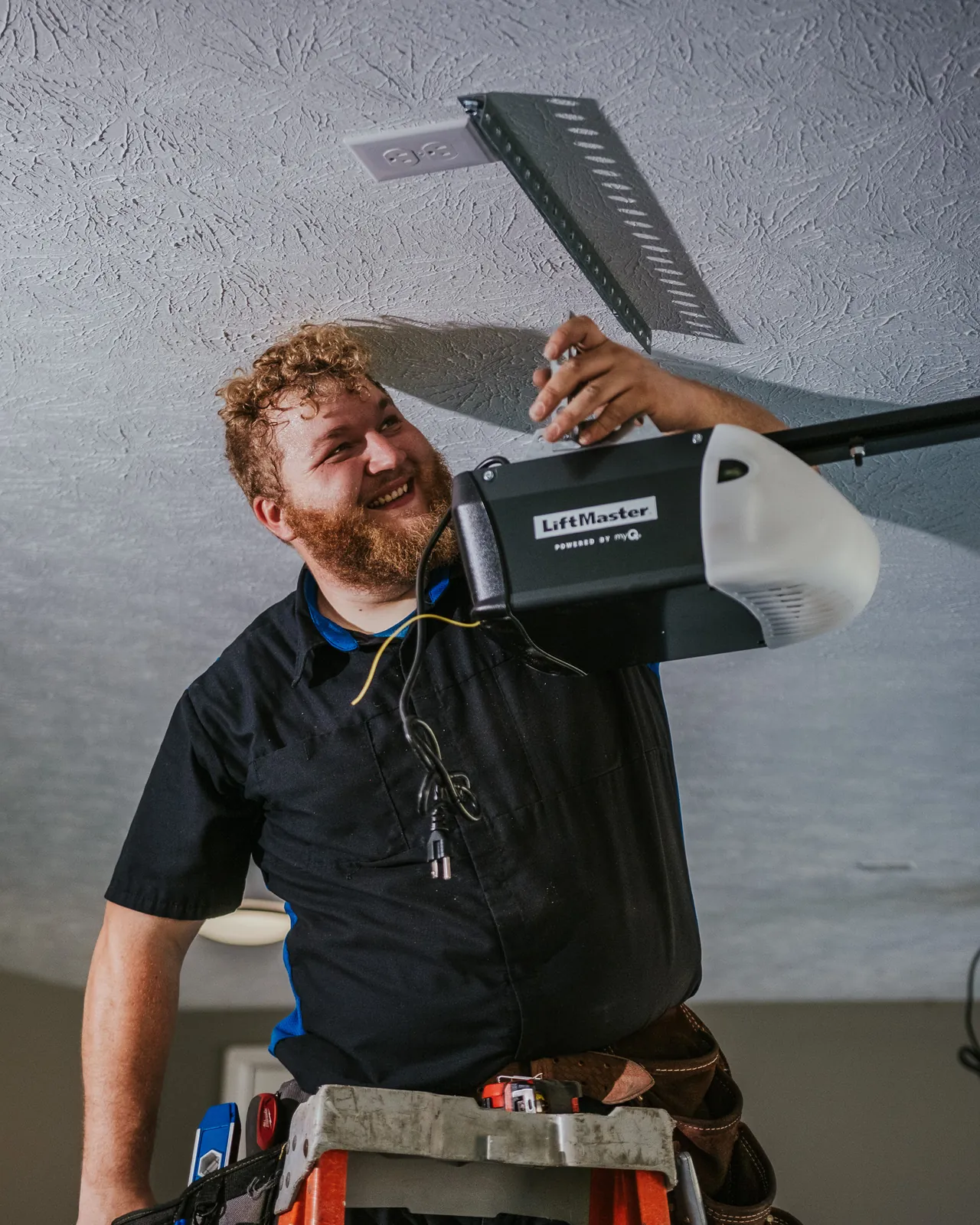 Blue Jay technician holding an opener beneath its mounting bracket