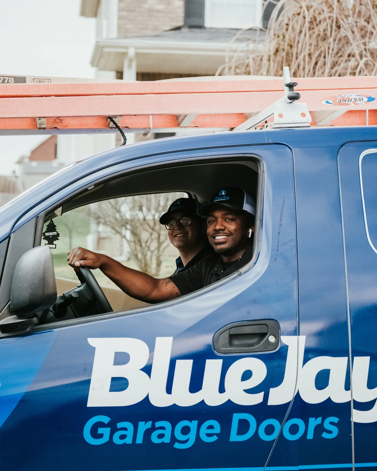 Blue Jay team members smiling from inside a service van