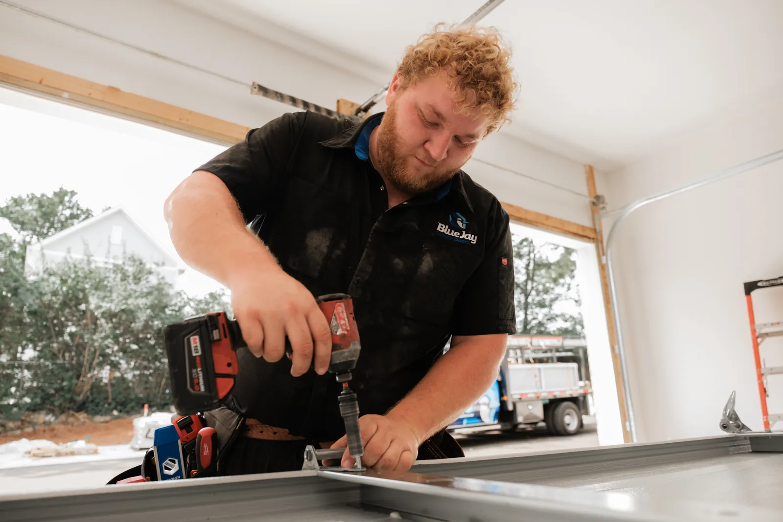 Blue Jay installer preparing a door section with a cordless drill
