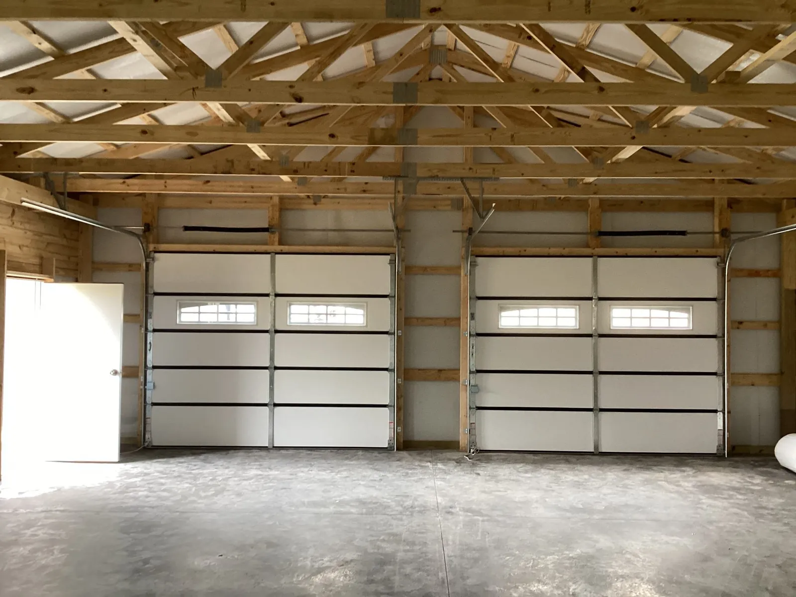 Interior of a detached garage with two white sectional doors