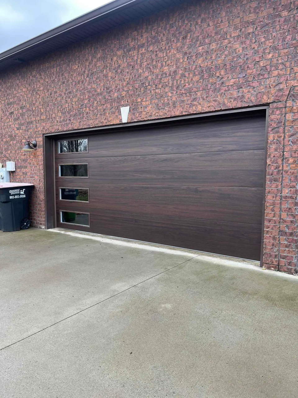 Wood-look garage door with horizontal lines and offset windows