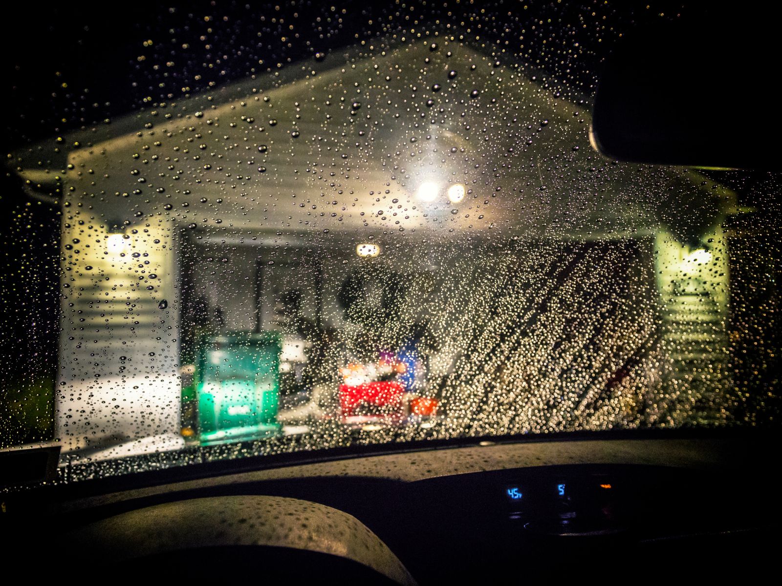 rainy garage car approaching garage door at night during the rain