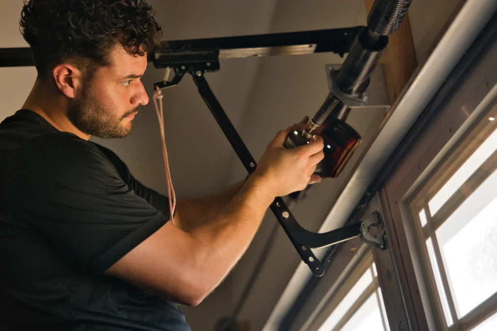 technician adjusting garage door spring