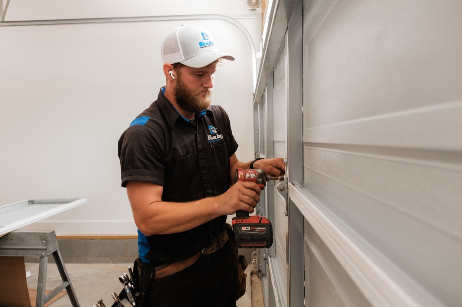 How Much Does a New Garage Door Cost in Clarksville, TN? Blue Jay technician installing hardware on a new garage door