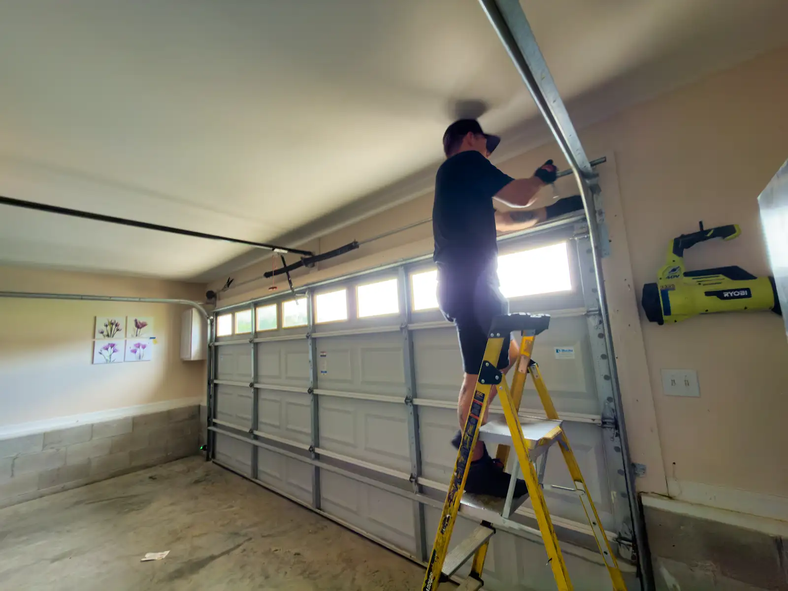 Garage Door Won't Close All the Way? 6 Causes and Which Ones You Can Fix Yourself Technician inspecting a garage door track and hardware